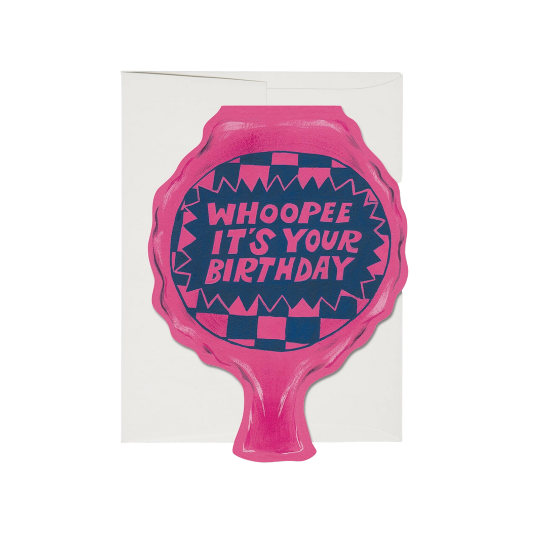 Illustrated pink and blue whoopee cushion with pink text "Whoopee It's Your Birthday". This 5x7 inch Whoopee Cushion Birthday Card is made of a 100lb heavyweight card stock, offset printed and die cut. It features an illustration by Krista Perry.