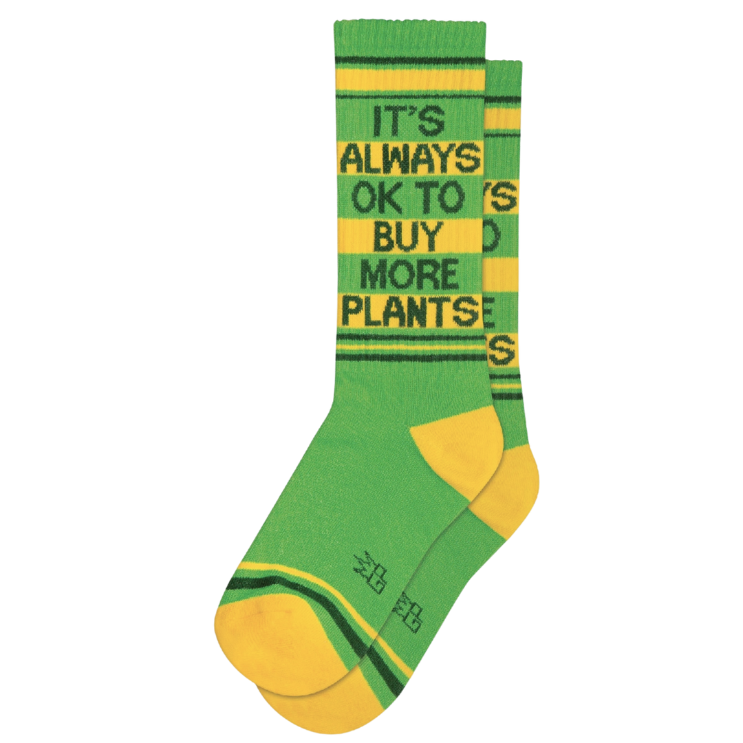 Green socks with yellow and dark green stripes and text "It's Always Ok To Buy More Plants". No space is off-limits when it comes to adding plants. From bathrooms to bedrooms, from basements to kitchens, and even offices, you can never go wrong with a new plant. It's Always OK To Buy More Plants Ribbed Gym Socks are made from a durable blend of 61% Cotton, 36% Nylon, 3% Spandex and are designed to fit most people. Made in the USA.