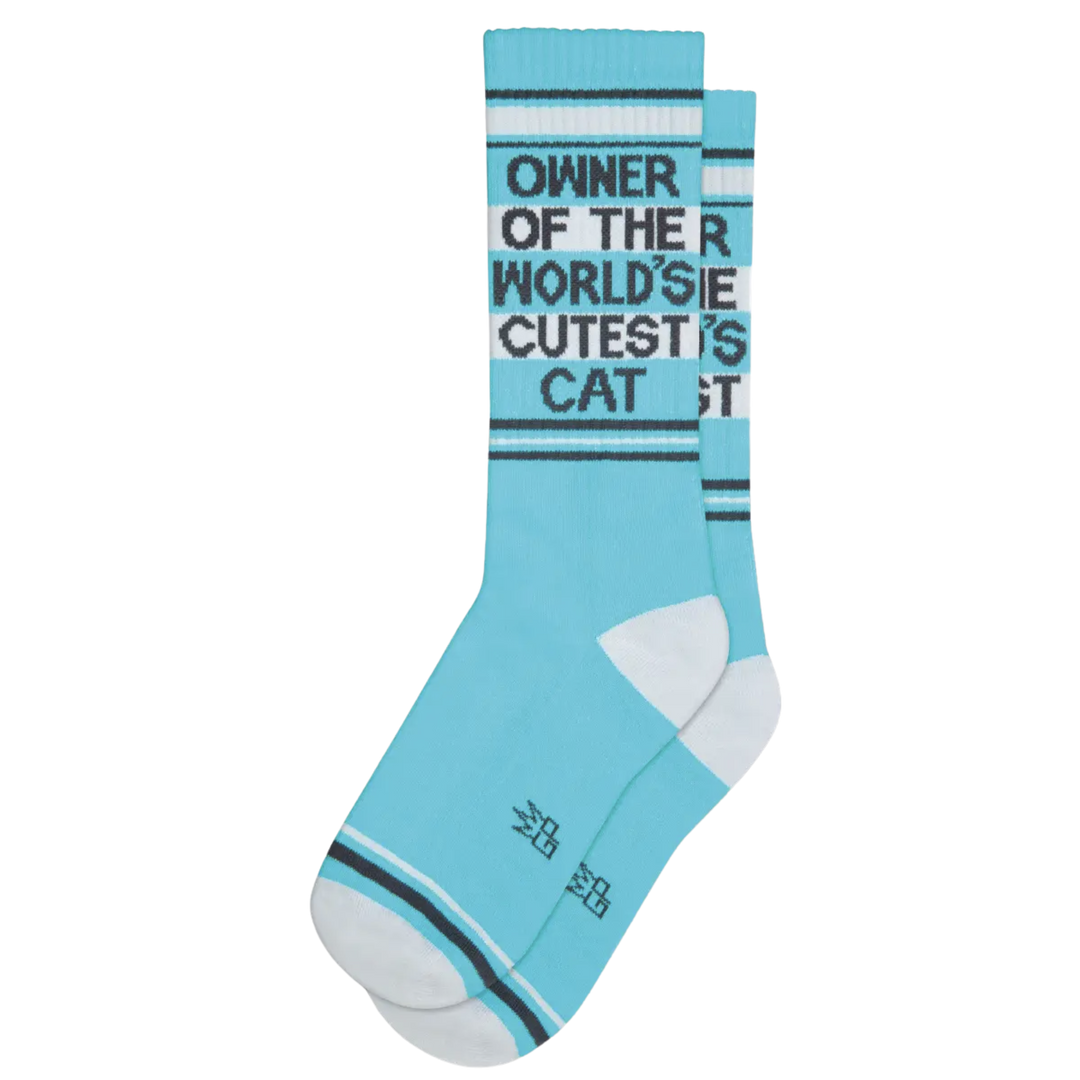Blue socks with white and grey stripes and text "Owner Of The World's Cutest Cat". Cast the spotlight on your cat's 'house cat confidence' with these stylish supporters.Soft and cushioned—and with a 'saunter-ready' look—they'll make your cat the envy of the neighborhood! 🐈 Made in the States: 61% Cotton, 36% Nylon, 3% Spandex.