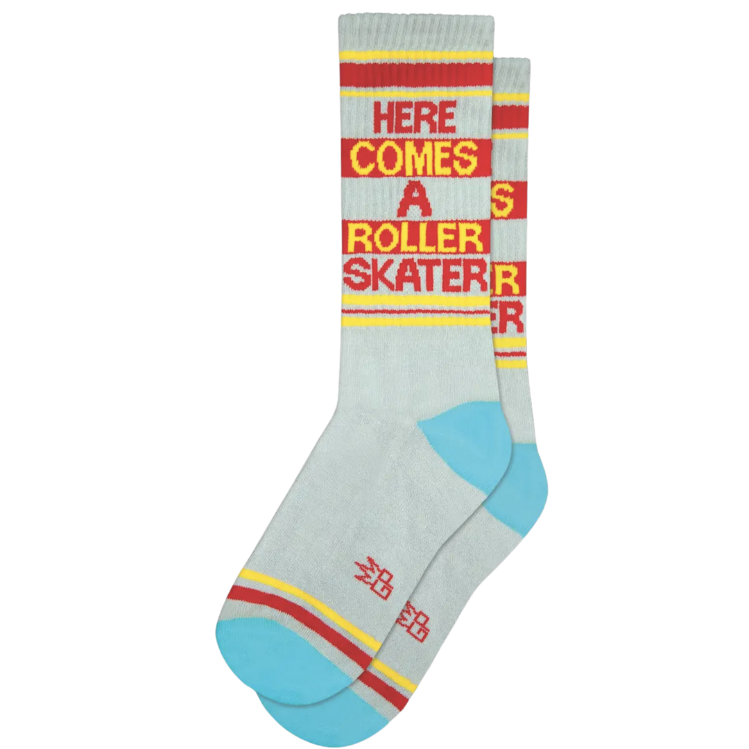 Grey socks with red and yellow stripes and text "Here Comes A Roller Skater". Introducing Our Superior Skate Socks! Show off your swift moves and leave your audience impressed. This cotton/nylon/spandex blend is designed in the USA and fits most sizes.