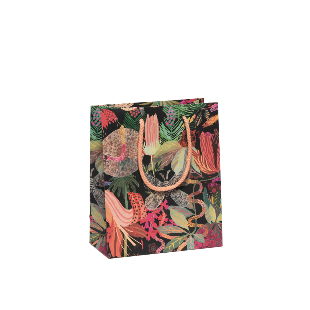 Multicolor floral print on black background with orange rope handles. Measuring 8"x4"x9.5", this Wild Kingdom Gift Bag is crafted from heavyweight coated paper, complete with a cotton rope handle and featuring charming illustrations by Michelle Morin.